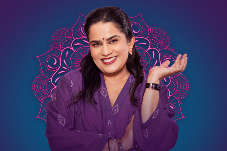 Indian-American comedian Zarna Garg smiling in a purple outfit against a pink mandala graphic background.
